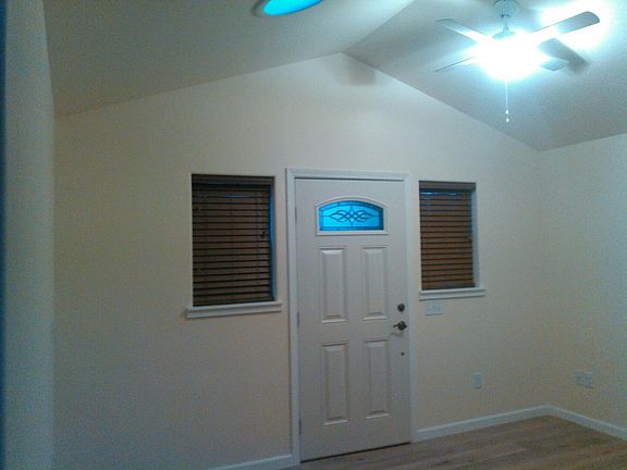 Cottage living room with vaulted ceiling, solar tube skylight, and ceiling fan.