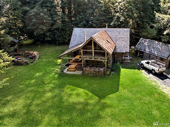Straight on view of amazing log cabin, fire pit & hot tub behind with disappearing truck on the right :)