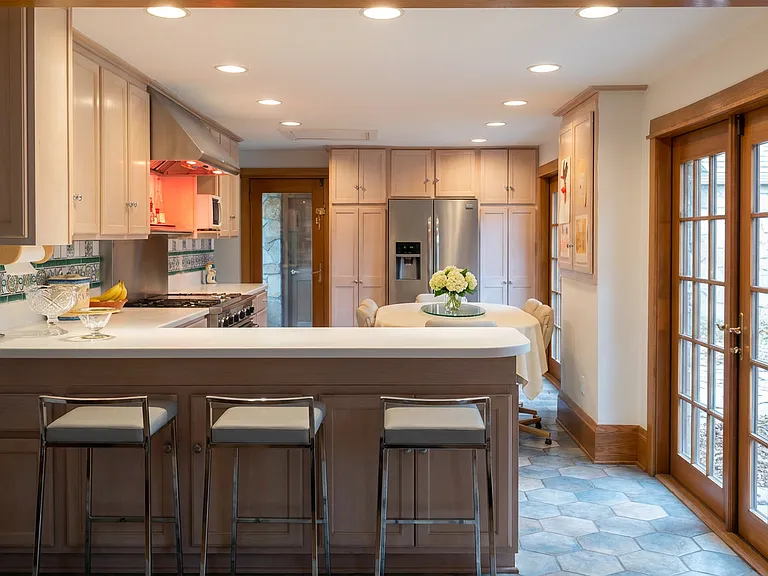 Spacious kitchen with a large center island, modern cabinetry, and French doors bringing in natural light.