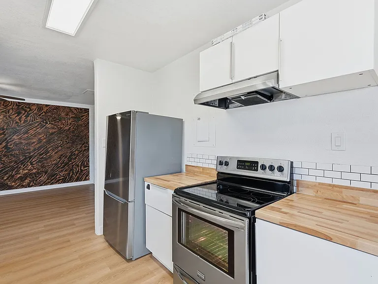 Kitchen flows nicely back into living room. Custom butcher block counter tops and tile backsplash.