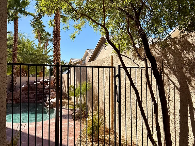 Private, gated pool area with mature landscaping and surrounding wall