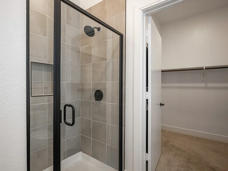 At Modera Trinity, step into luxury with standing showers embellished with striking black hardware, seamlessly blending modern design and functionality for a truly indulgent bathing experience.