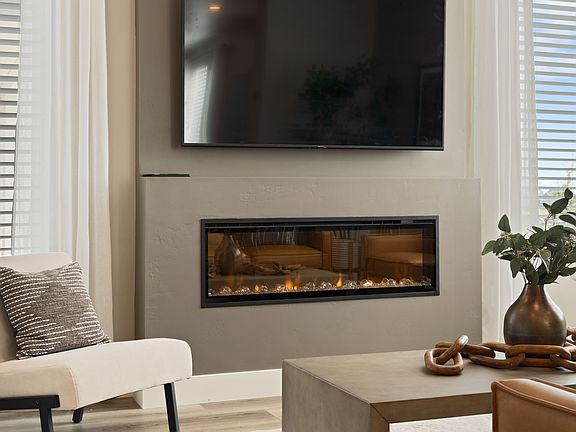 The Legacy of modern design shines in this living room, featuring a wall-mounted TV, linear fireplac