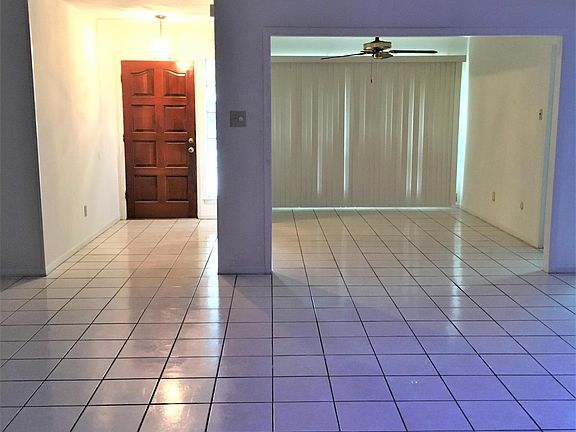 The formal dining room with ceiling fan is right beside the front entrance