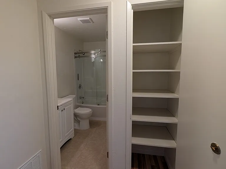 Hallway looking at bathroom and closet (opened)
