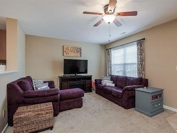 Great room features neutral color paint and carpeting.