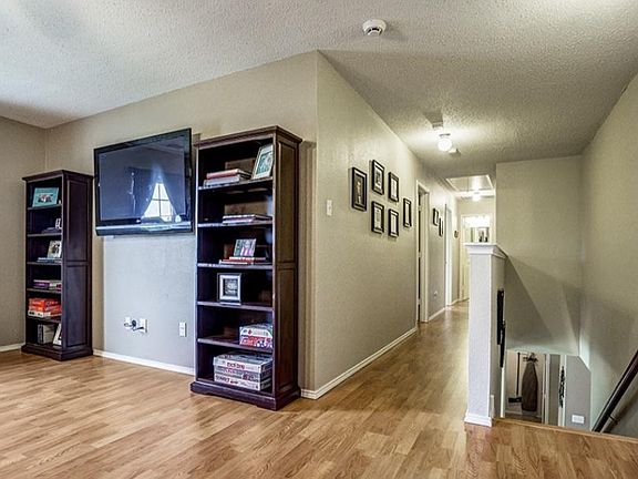 Upstairs game room with a view of hallway down to two bedrooms and a bathroom (flooring is currently being replaced).