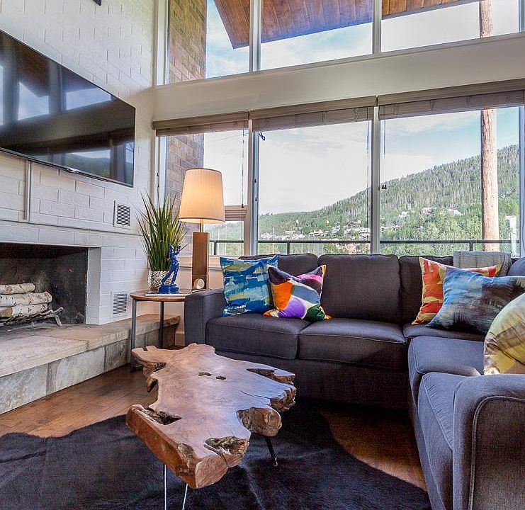 Living room with open concept, vaulted ceilings, sectional sofa and chairs.