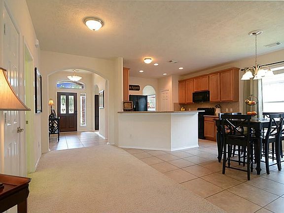 Guests open the front door and are greeted by this impressive Foyer with arched openings and designer light fixtures
