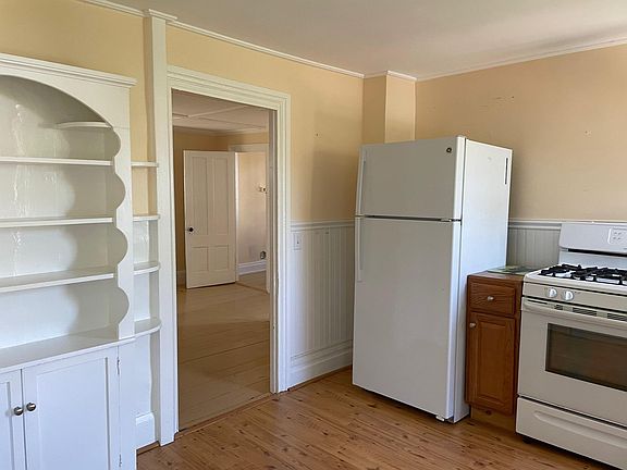 kitchen into dining room, w/ fridge, stove, display cabinet