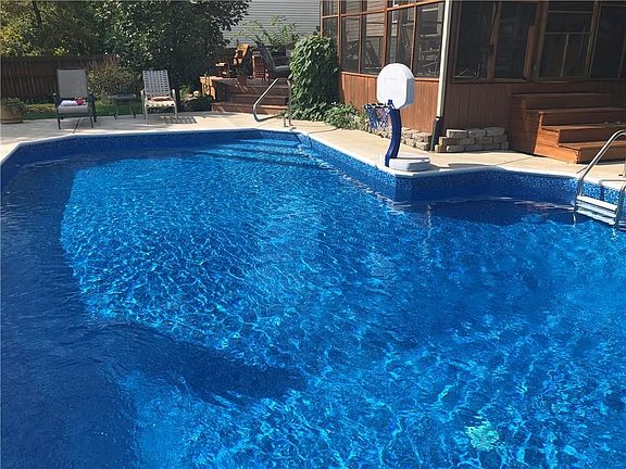Another view of the pool, concrete deck, wood deck and screened-in porch as well.