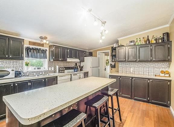 Modern kitchen with ample storage and beautiful counter tops, backsplash, and wood floors.
