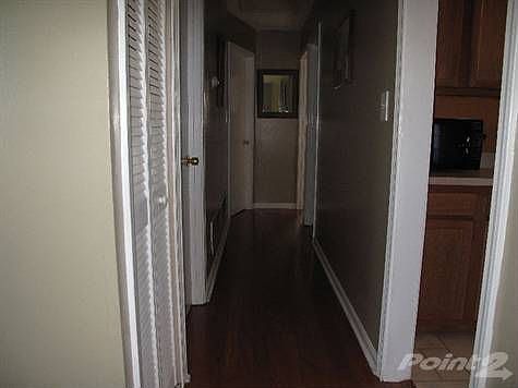 hall way with extra closets and hardwoods