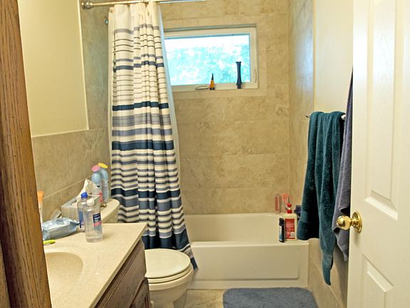 Main Level Bath. Modernly remodeled bathroom with floor to ceiling tile in shower