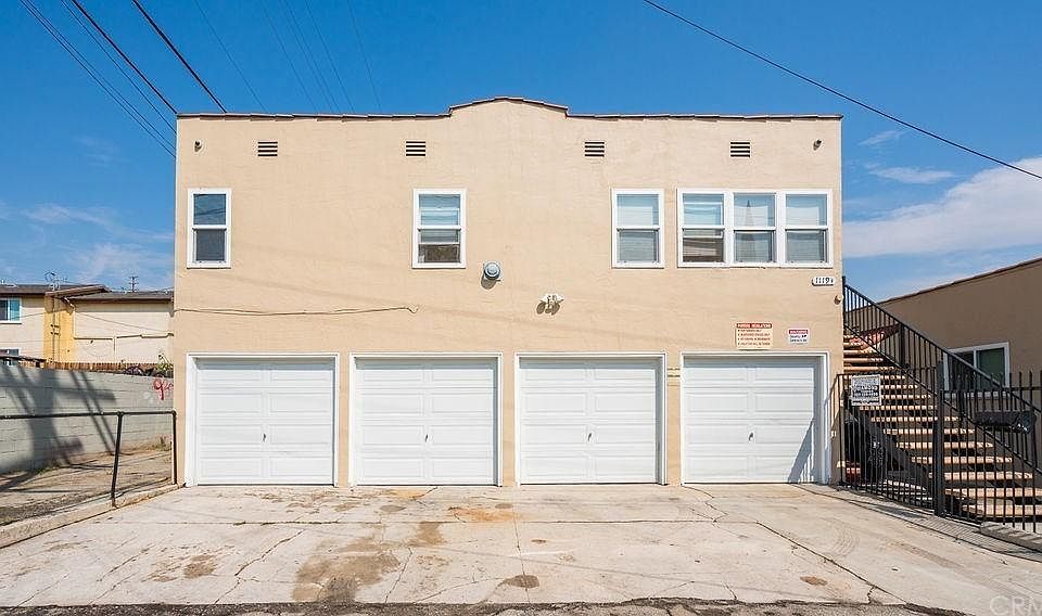 The apartment is on the 2nd floor, up the stairs that are on the right side of this photo. The far left garage bay and parking spot in front of it are also reserved for this unit.