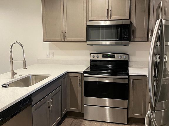 Stainless steel appliances and custom built ceiling-high cabinets