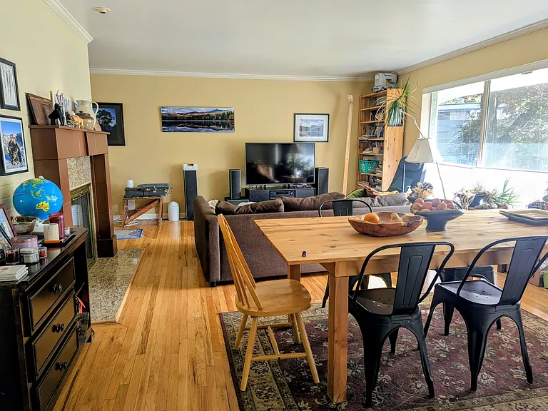 Open space dining and living room with large windows to the front of the house