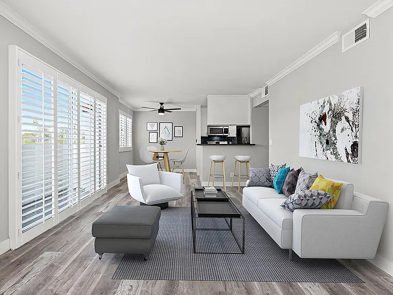 Living room with hardwood floor and large windows for natural light.