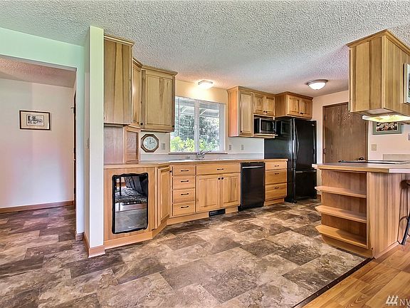 View of entry leading to kitchen, all appliances stay and notice wine fridge. 