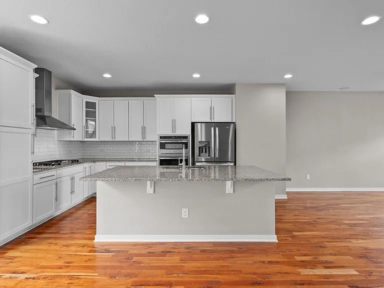 Gas range, full size fridge, counter for bar stools, and microwave and oven.
