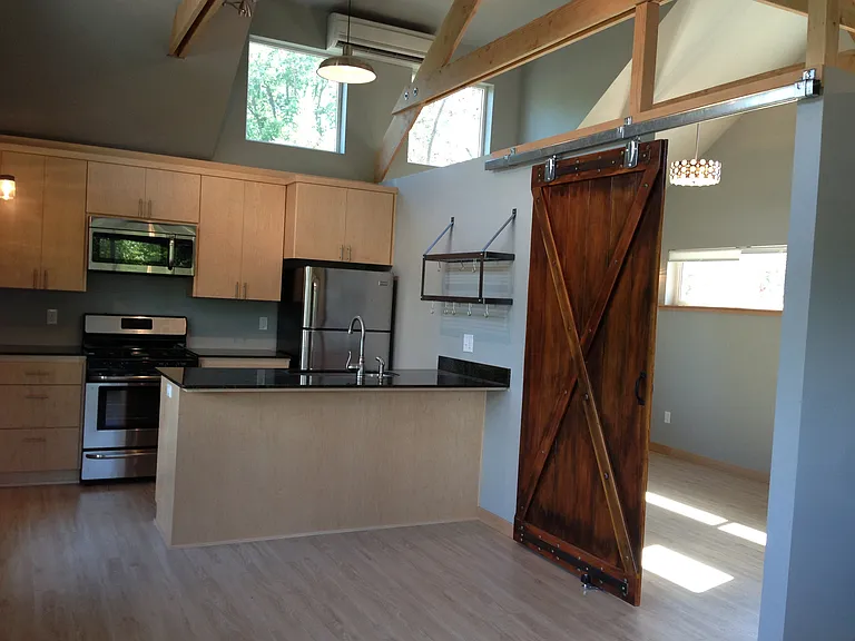Kitchen and living space with view into bedroom.