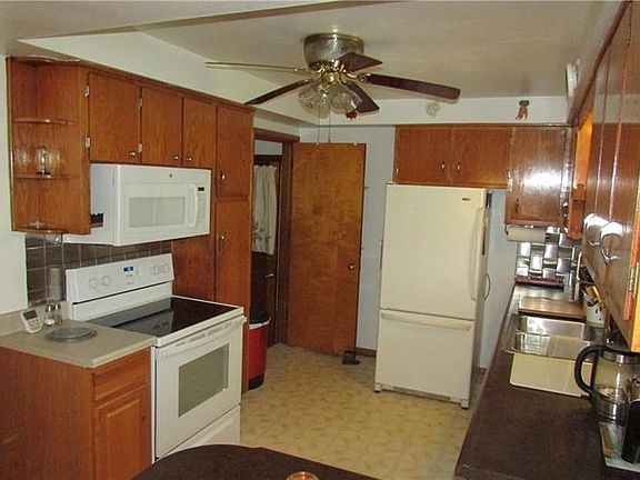 Oak kitchen with all appliances. Stainless steel backsplash.