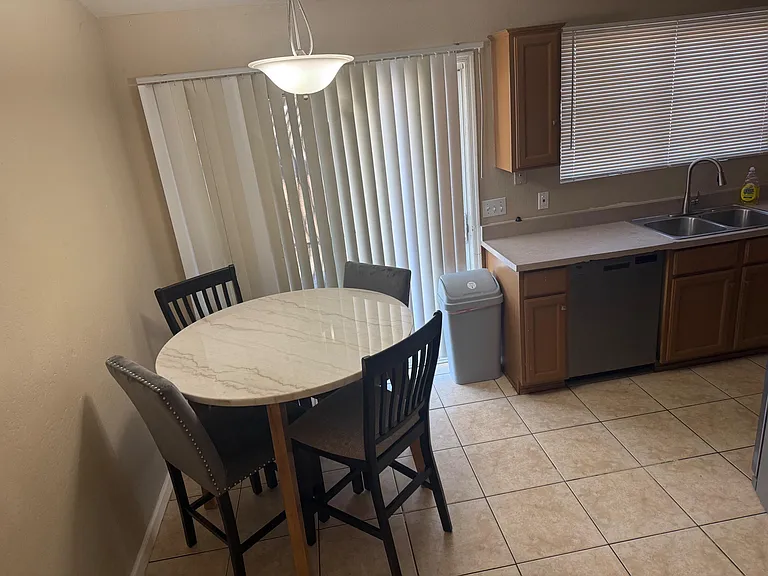 Eat-in kitchen nook with a round table, tile flooring, and convenient access to the sink and counter space.