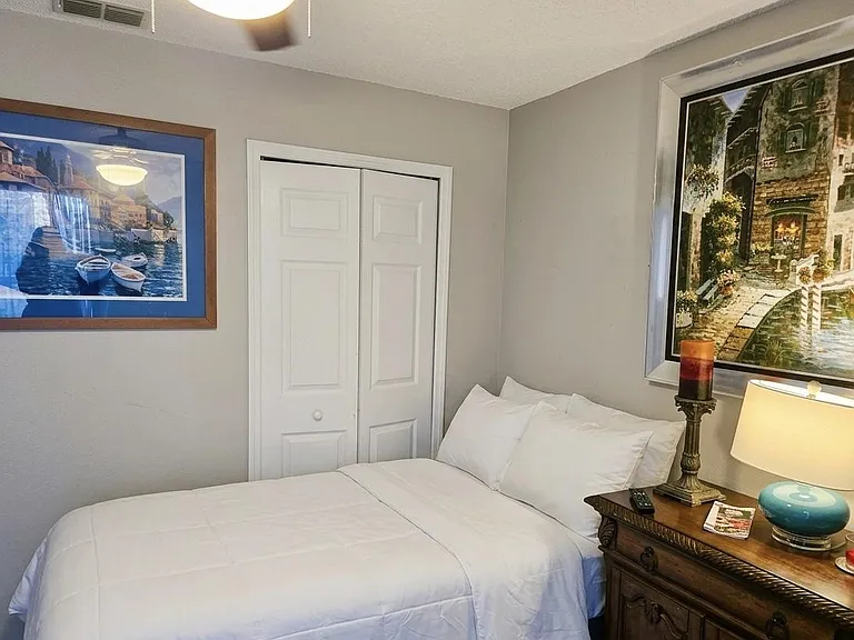Comfortable bedroom with a double bed, nightstand lighting, and a sliding-door closet for convenient storage.