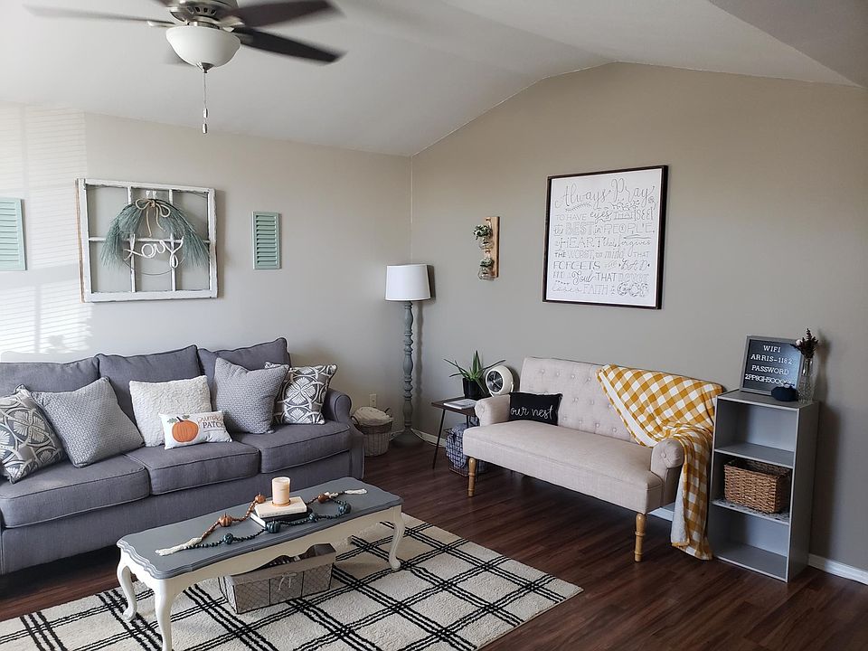 living room 15X18. vaulted ceiling, hardwood floor, accent wall, warm colors.
