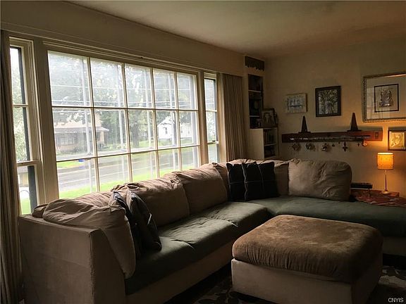 Nice sized living room with built in shelves on either side of picture window.