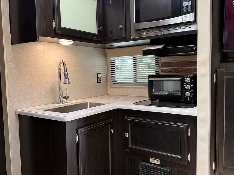 Skylight above kitchen has shade cover option. Toaster and convection microwave ovens