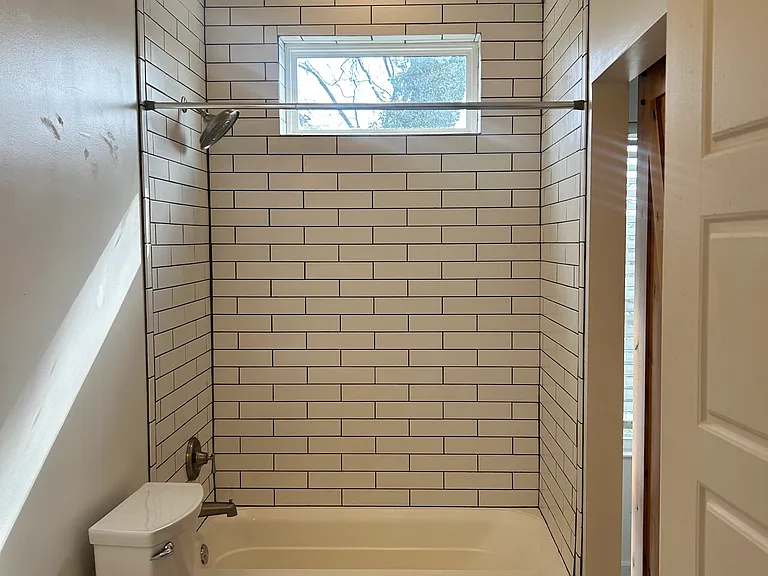 Bathroom floor has floor to ceiling tile in shower/tub combo. As well as granite countertops and tile floors.