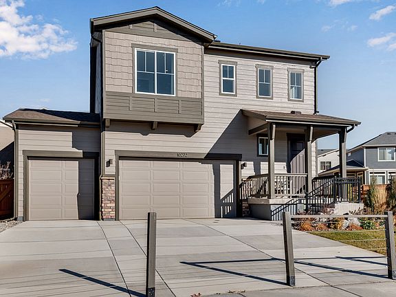 A modern two-story residential house with a garage, surrounded by a paved driveway and a well-mainta