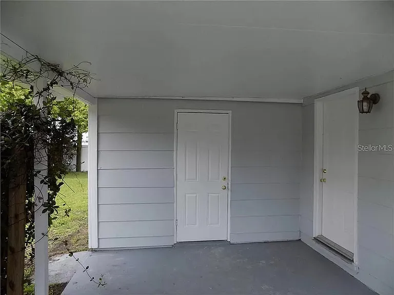 Car port and inside that door is the washer and dryer