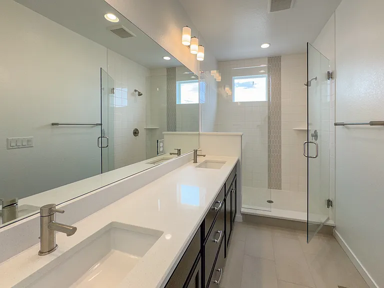 Spacious master bathroom with elegant finishes, dual sink and glass enclosed shower