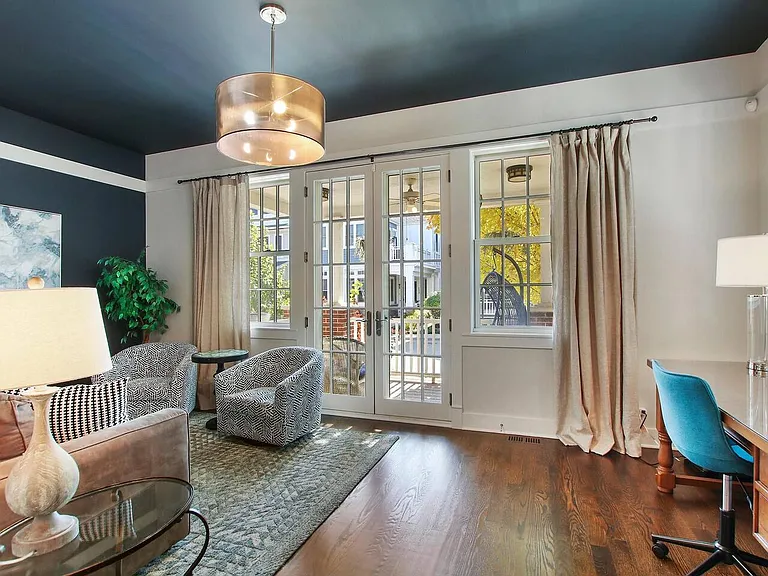 First Floor: Front sitting room with dedicated office area and double french doors open to covered porch