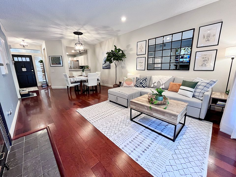 Elegant living and dining room for 4-6 flowing into the kitchen and outdoor living area, featuring a new Pottery Barn slipcovered sectional sofa _ perfect for movie nights or as a pull-out bed for guests _ alongside a gas fireplace and 65" Smart TV.