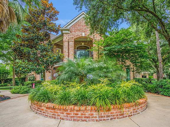 Circular brick planter filled with lush landscaping.