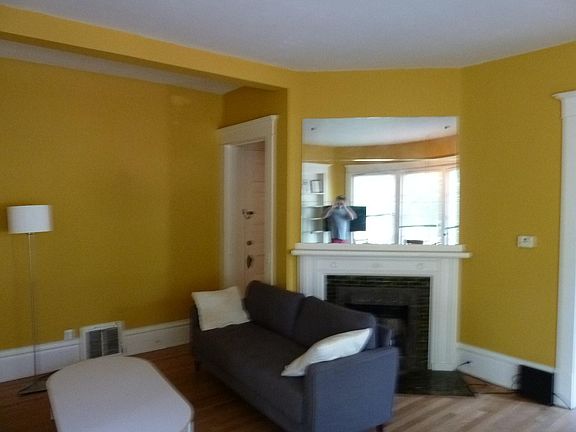Living Room looking to SW at decorative fireplace and door to basement. To right of basement door is bathroom (behind fireplace)