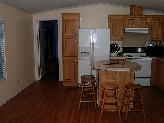 Island Kitchen with wood laminate floors, crown molding, and plenty of cabinets. Refrigerator stays!