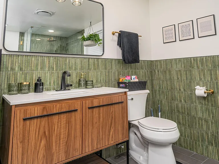 Stylish bathroom featuring a wide vanity with ample storage, large mirror, and a glass-enclosed shower for easy upkeep.