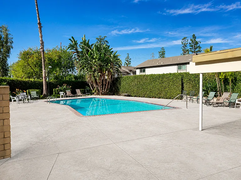 HOA community pool with lounge seating and a well-maintained outdoor area for residents to enjoy.
