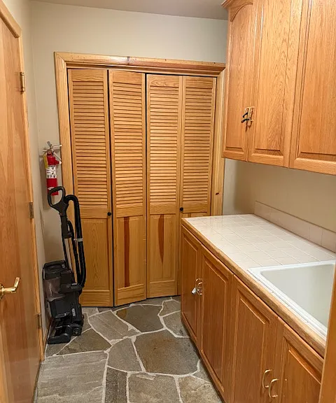 Laundry room with exensive cabinets and laundry sink