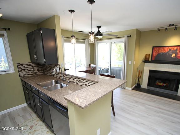 Shows new flooring and freshly painted cabinets (Sherwin Williams Iron Ore SW7069).