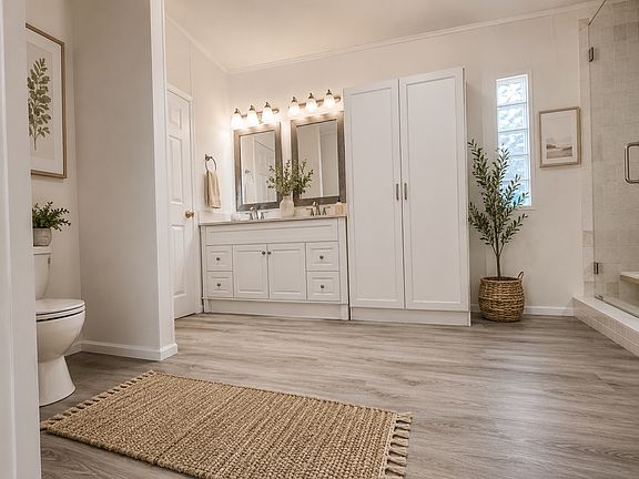 **The spacious primary bathroom features a double vanity, walk-in shower, and a large linen/storage closet for added convenience.**