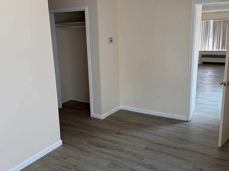 Bedroom, with view to kitchen and closet area beyond