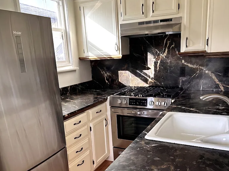 Saint Laurent marble counter tops and stainless appliances including dishwasher