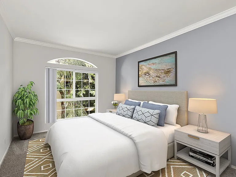 Carpeted bedroom featuring beautiful natural lighting and ceiling fan.