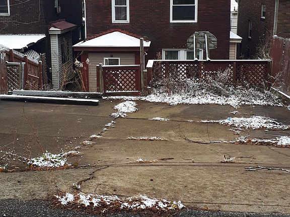 Rear of house and off street parking pad. Below is the back patio, which has a rear door entry into the kitchen.