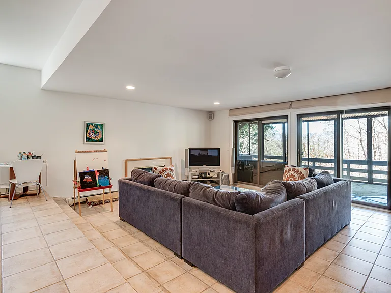 Lower level TV/Game Room leads to lower level deck with screen porch and hot tub.
